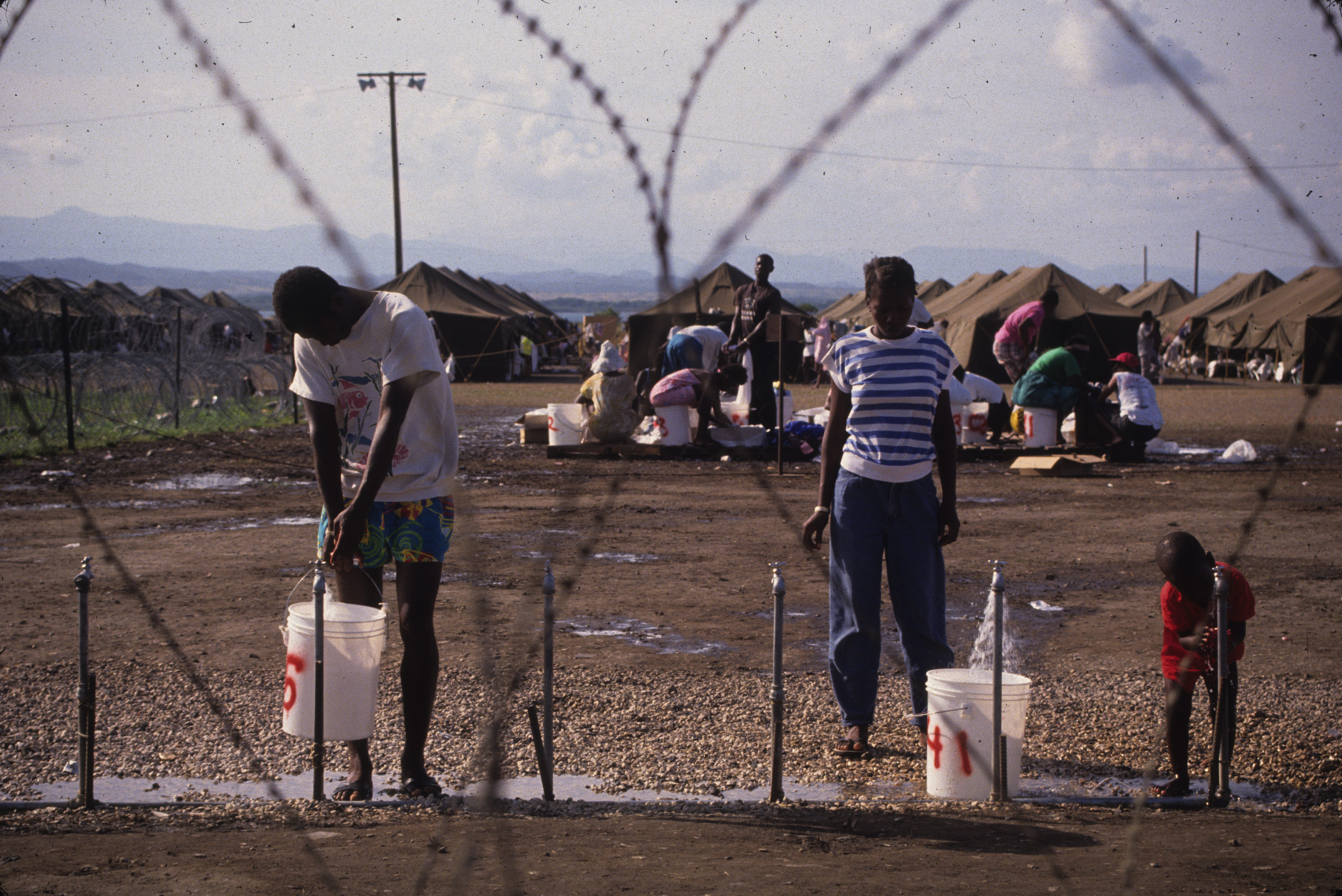 Refugees filling up water buckets at Camp McCalla, 12.31.91